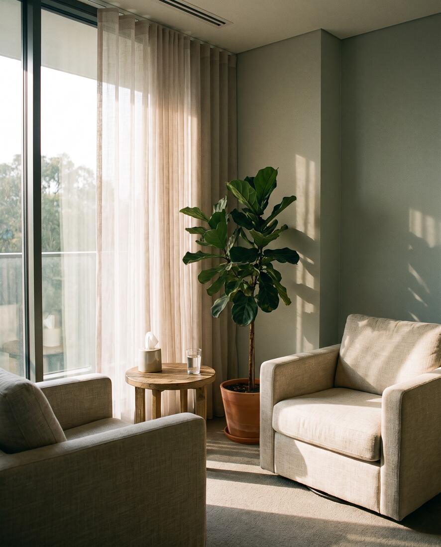 A quiet counselling room with two linen armchairs in afternoon light